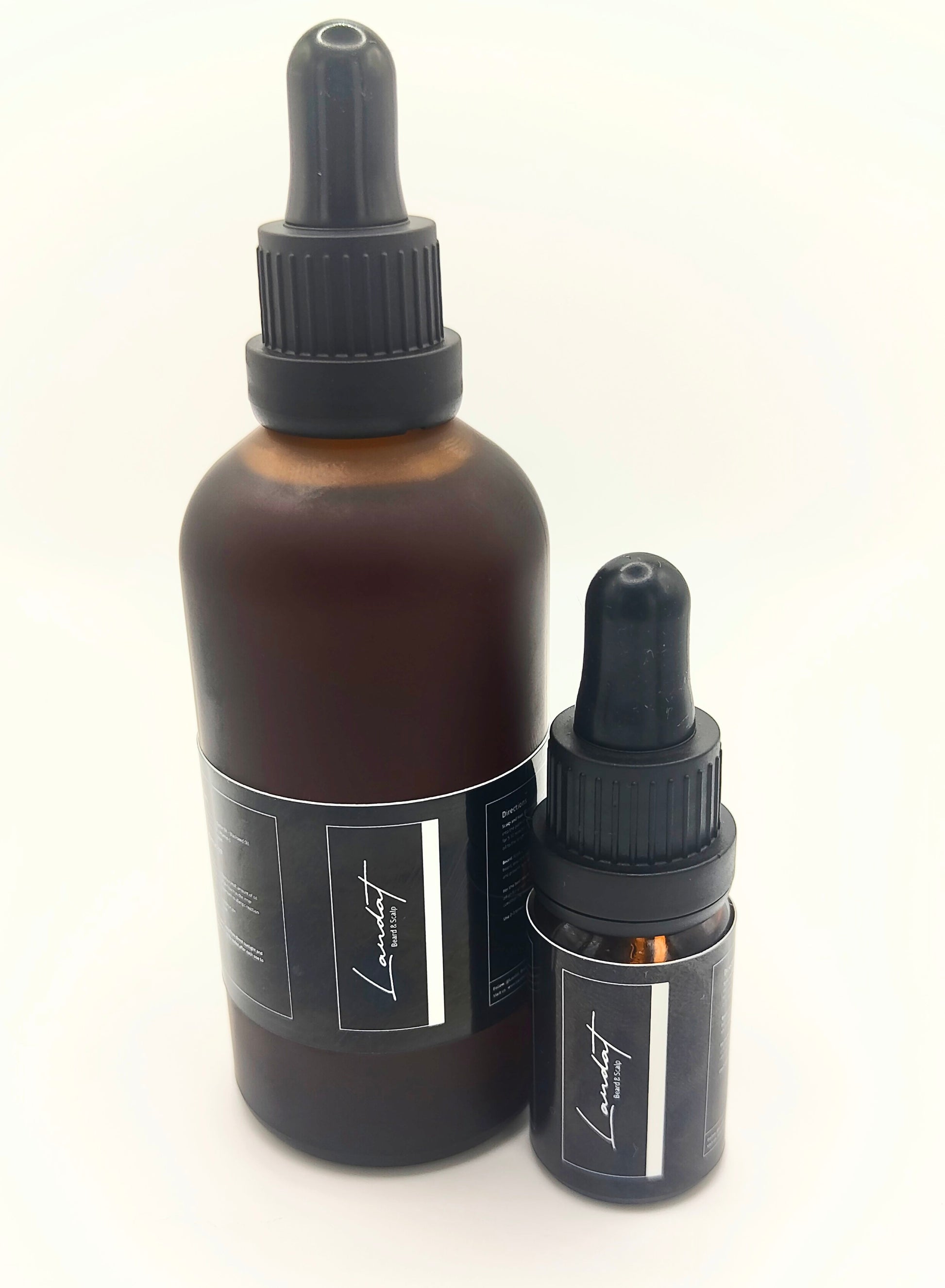 Two brown glass bottles with black droppers on a white background